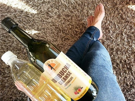 コンブチャクレンズとペットボトルを持った女性